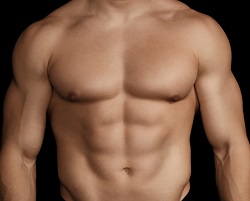 close up of muscular male torso in front of black background